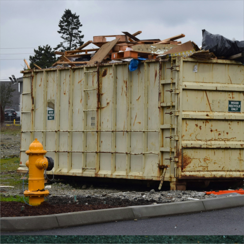 Large roll-off dumpster filled with construction debris, showcasing Professional Dumpster Rental in Whitehall, MI for residential cleanouts, construction projects, remodeling waste, and dependable debris removal.