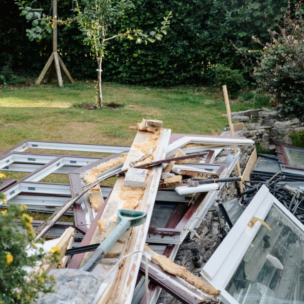 Home renovation debris including old window frames, construction materials, and discarded fixtures prepared for convenient dumpster rental in North Muskegon, MI.