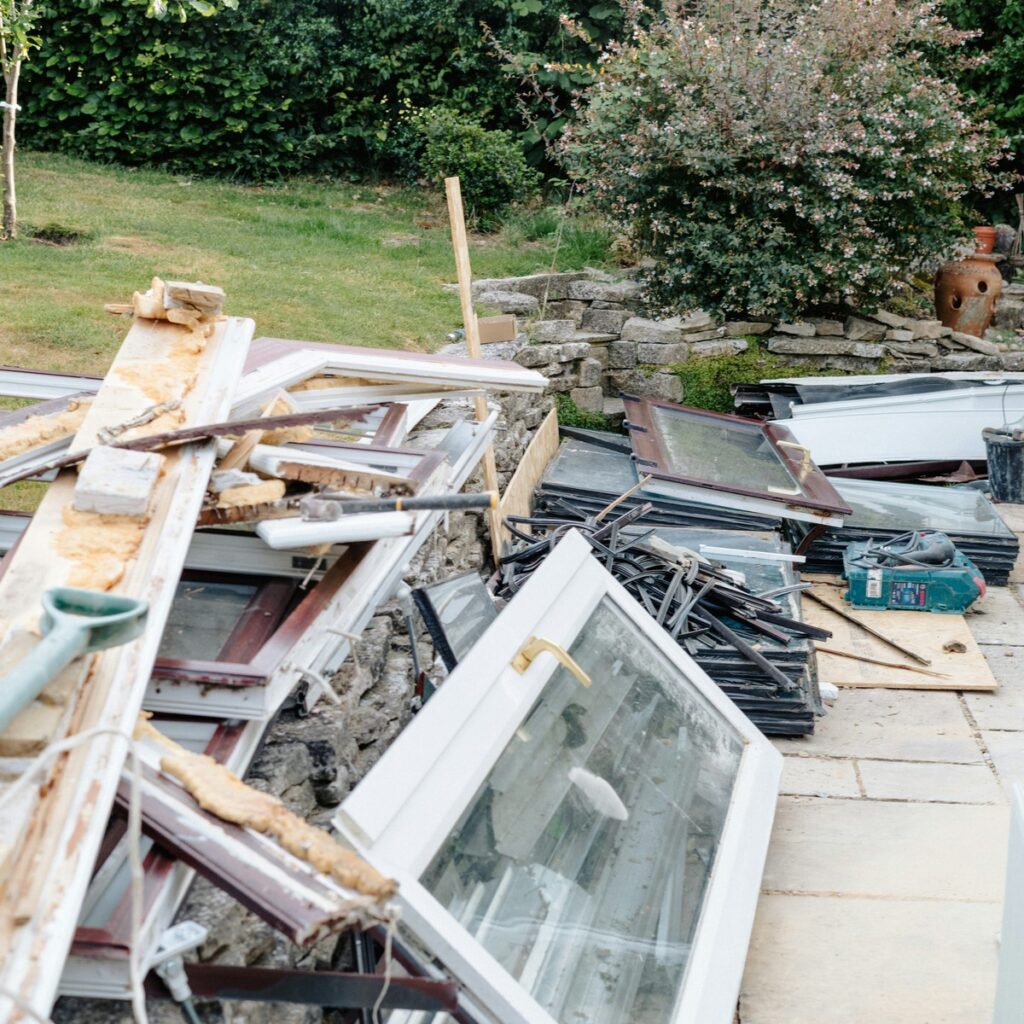Home renovation debris with discarded window frames, construction materials, and fixtures ready for efficient dumpster rental in Fruitport, MI.